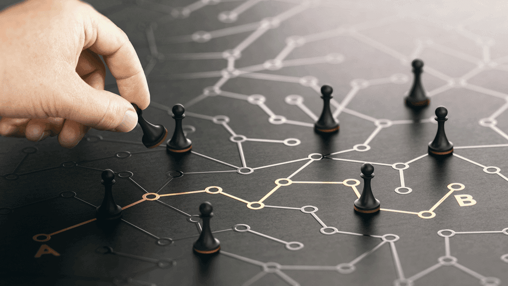 a photo showing a hand moving a pawn across a grid of connected dots portraying a network of pathways