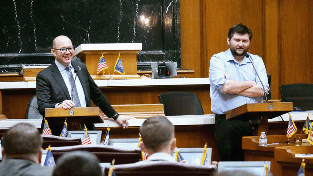 a photo of two Indiana state representatives speaking to members of the Future Leadership Division inside the House chamber