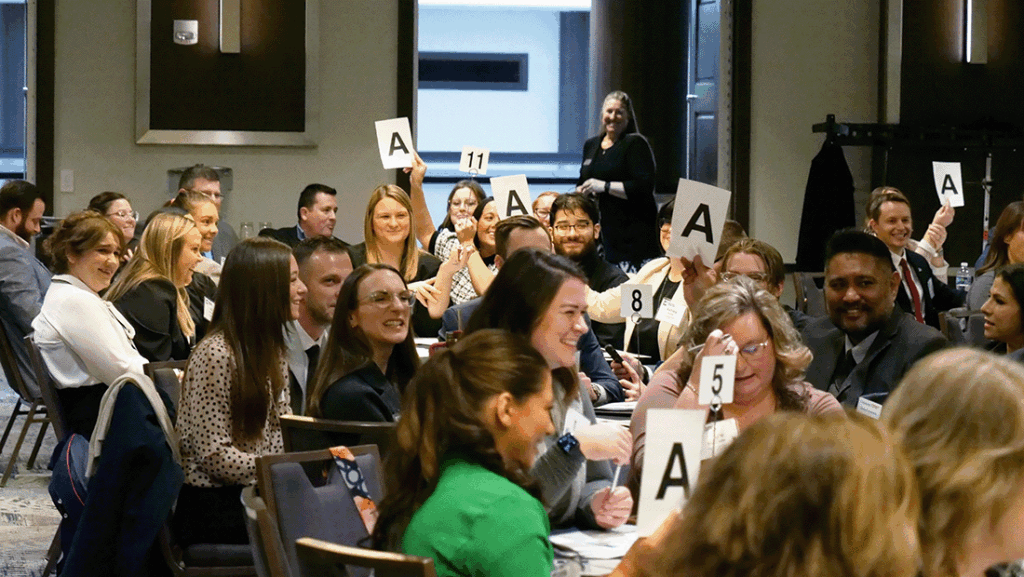 a photo showing dozens of bankers competing in a trivia challenge