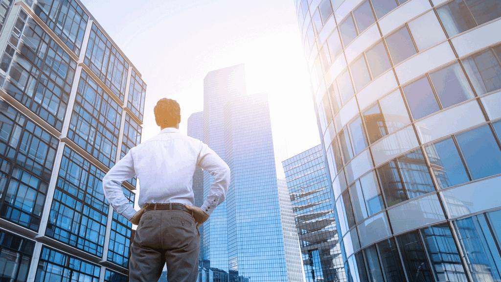 an stock image of a man standing and looking up amid a series of skyscrapers