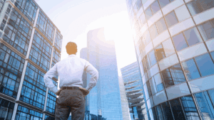 an stock image of a man standing and looking up amid a series of skyscrapers