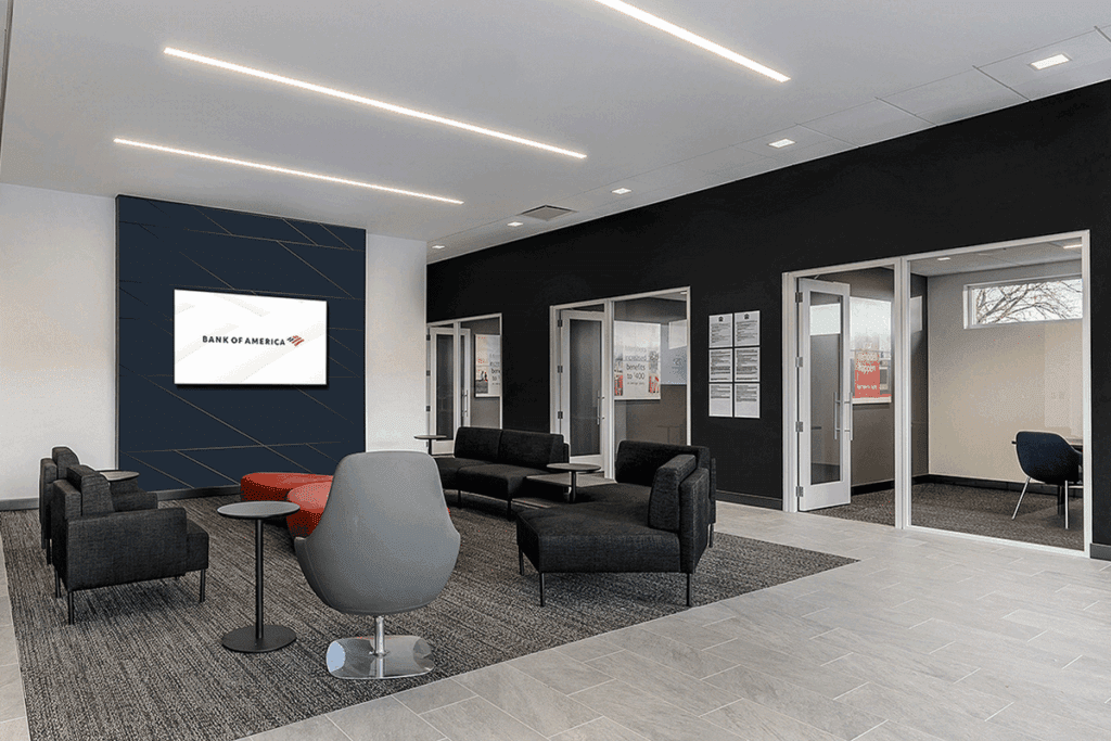 a photo showing comfortable chairs in a commercial building's lobby next to a row of private offices