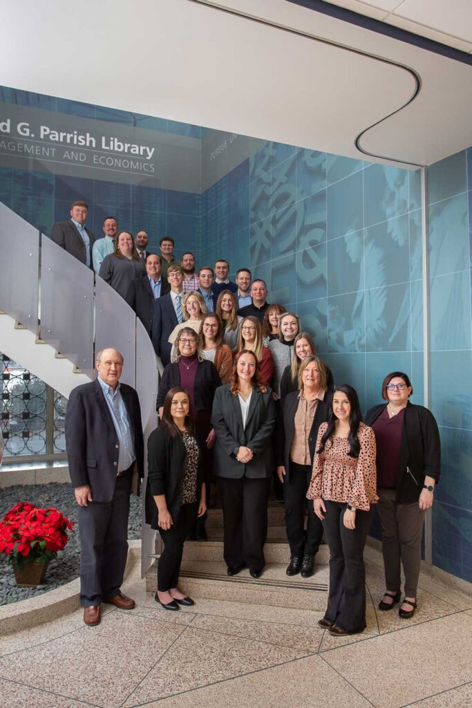 a photo showing the 2024 IBA Midwest Agricultural Banking School graduating class standing on a spiral staircase