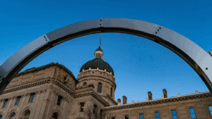 a photo of the Indiana Statehouse including an art piece on the Statehouse grounds