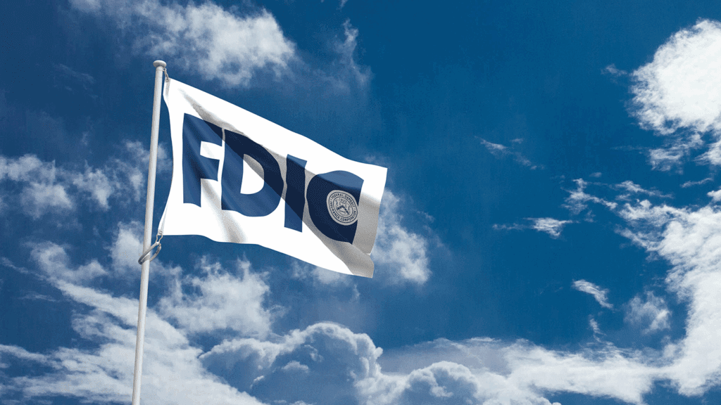 a white flag with an all-blue FDIC logo flying against a blue sky with white clouds