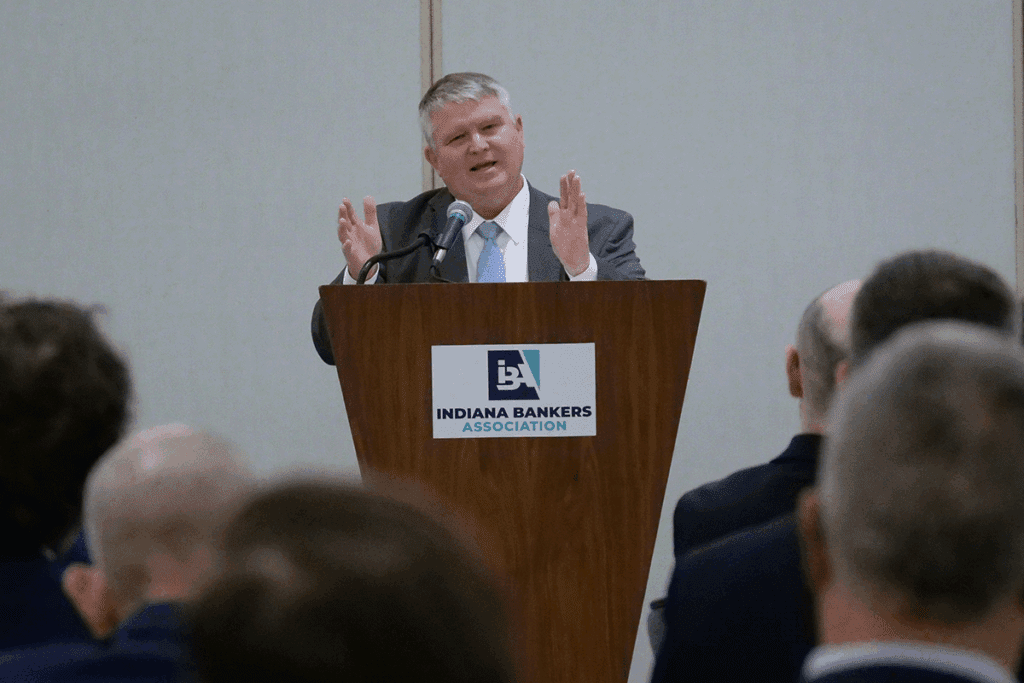 a photo of Tom Fite speaking from a wooden lectern with a logo of the Indiana Bankers Association on the front