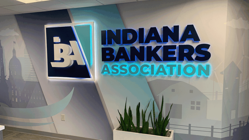 a photo showing the IBA logo as a lit sign on a wall inside the IBA office