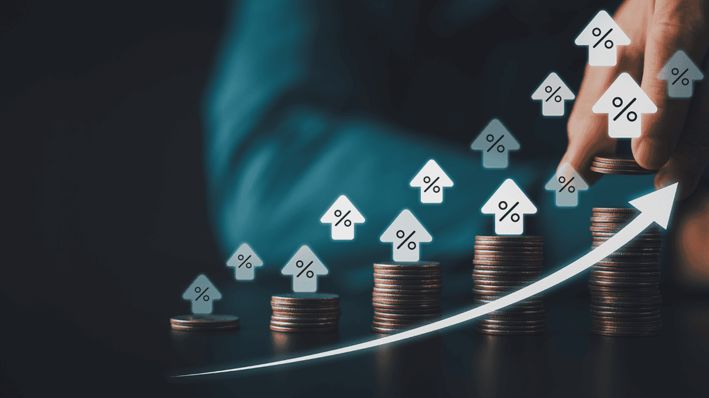 Stacks of coins increasing in height with percent arrows and a rising white line, signaling financial growth or rising rates.