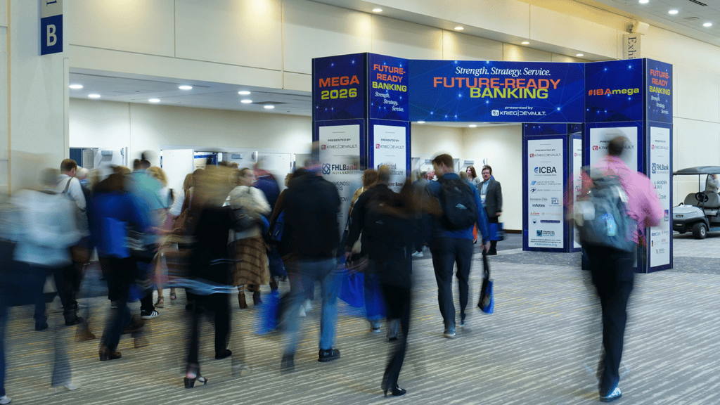 a crowd of people walking into a conference center hall