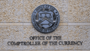 a photo of the office's seal on an exterior wall at the Office of the Comptroller of the Currency in Washington, D.C.