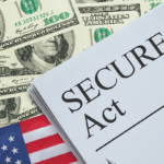 Document labeled 'SECURE 2.0 Act' resting on a stack of US $100 bills and a small American flag, suggesting financial legislation context.