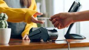 a photo of a customer handing a vendor their debit card