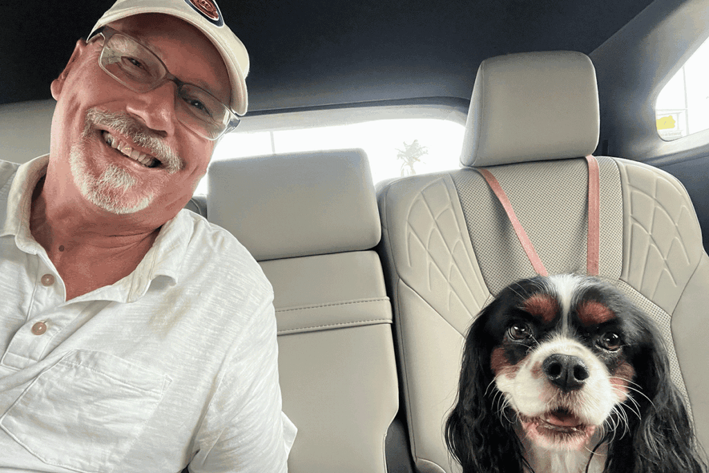A man in white poses for a picture with his dog