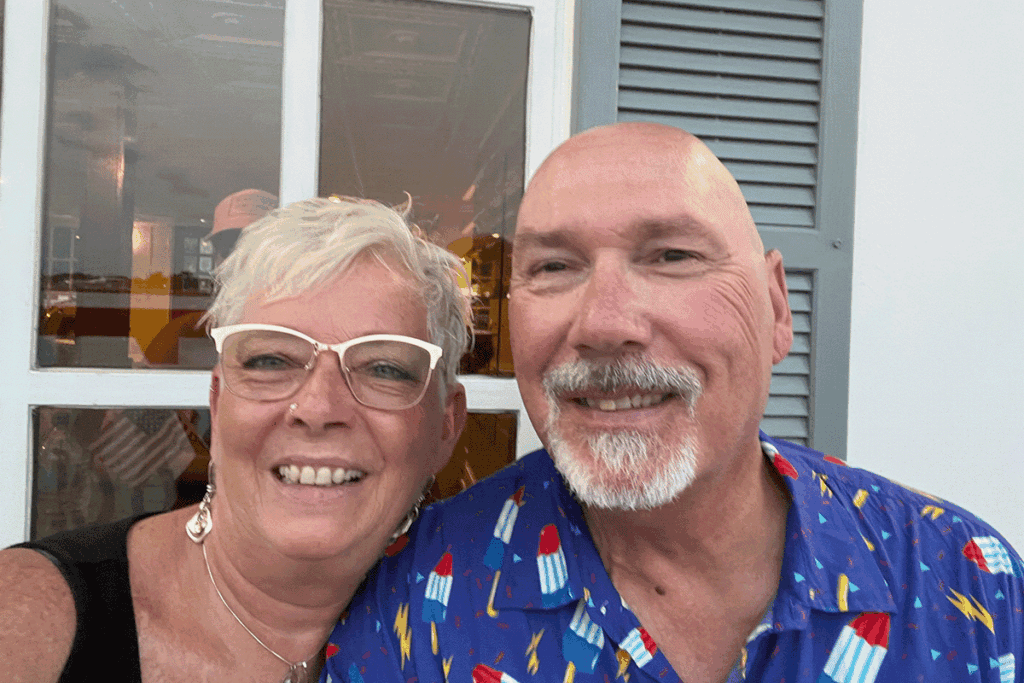 an older couple poses for a casual photo on vacation